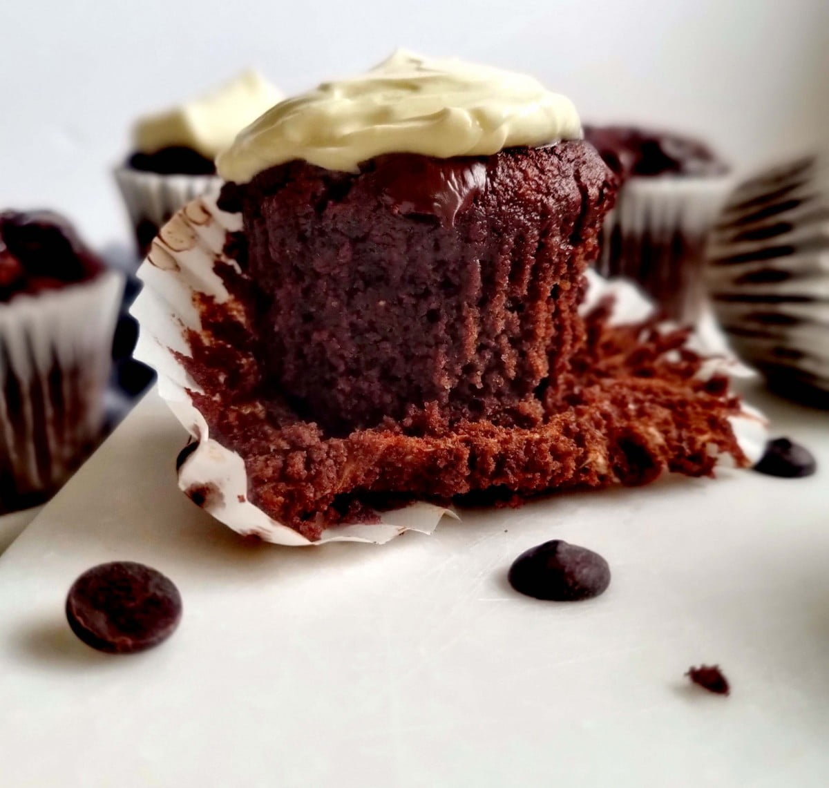 close up low carb double chocolate muffins with banana cream cheese frosting