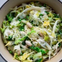 creamy cabbage and white beans in saucepan