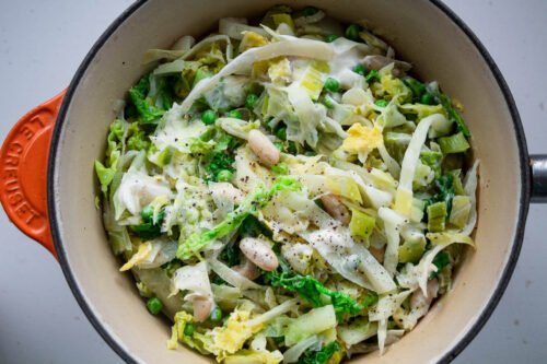 creamy cabbage and white beans in saucepan