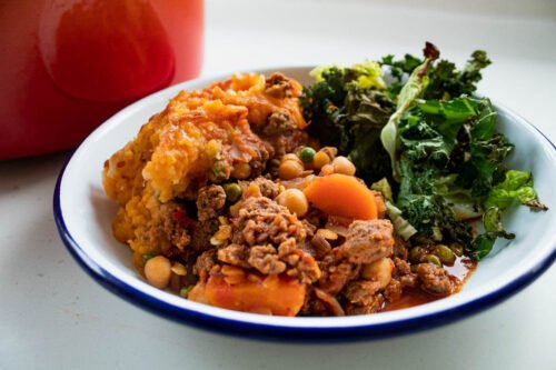 Vegetarian cottage pie on a plate with greens