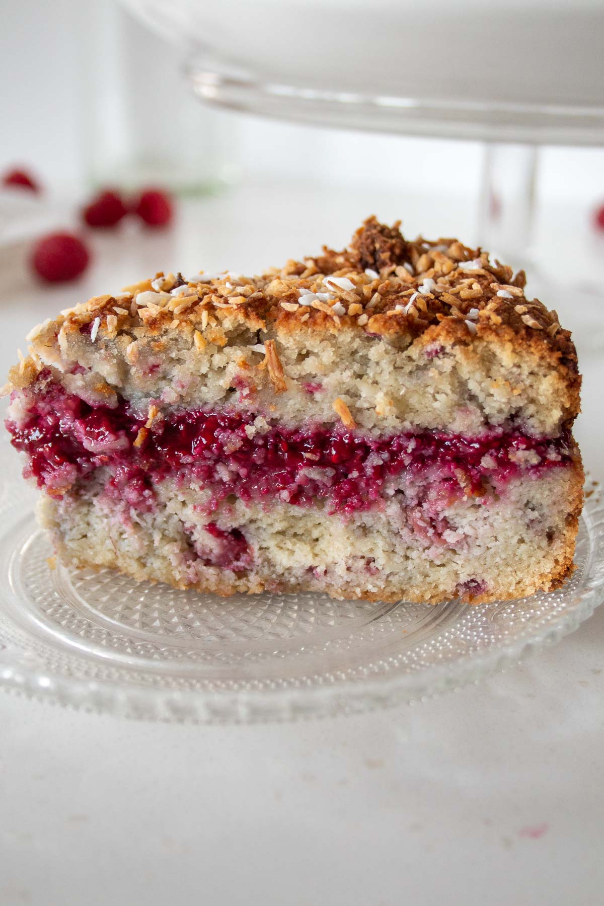 closeup of a slice of coconut raspberry cake on a plate