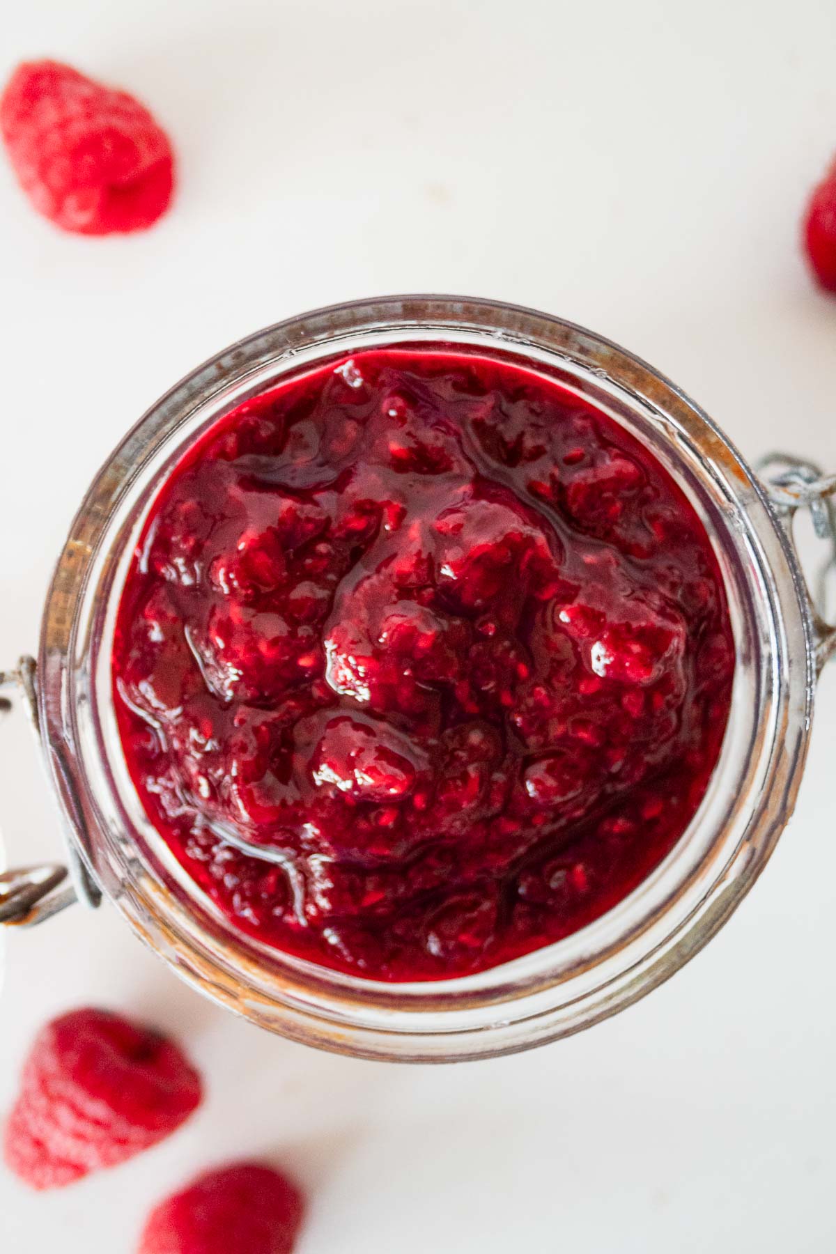 Easy sugar free jam for diabetics in a jar with raspberries in the background