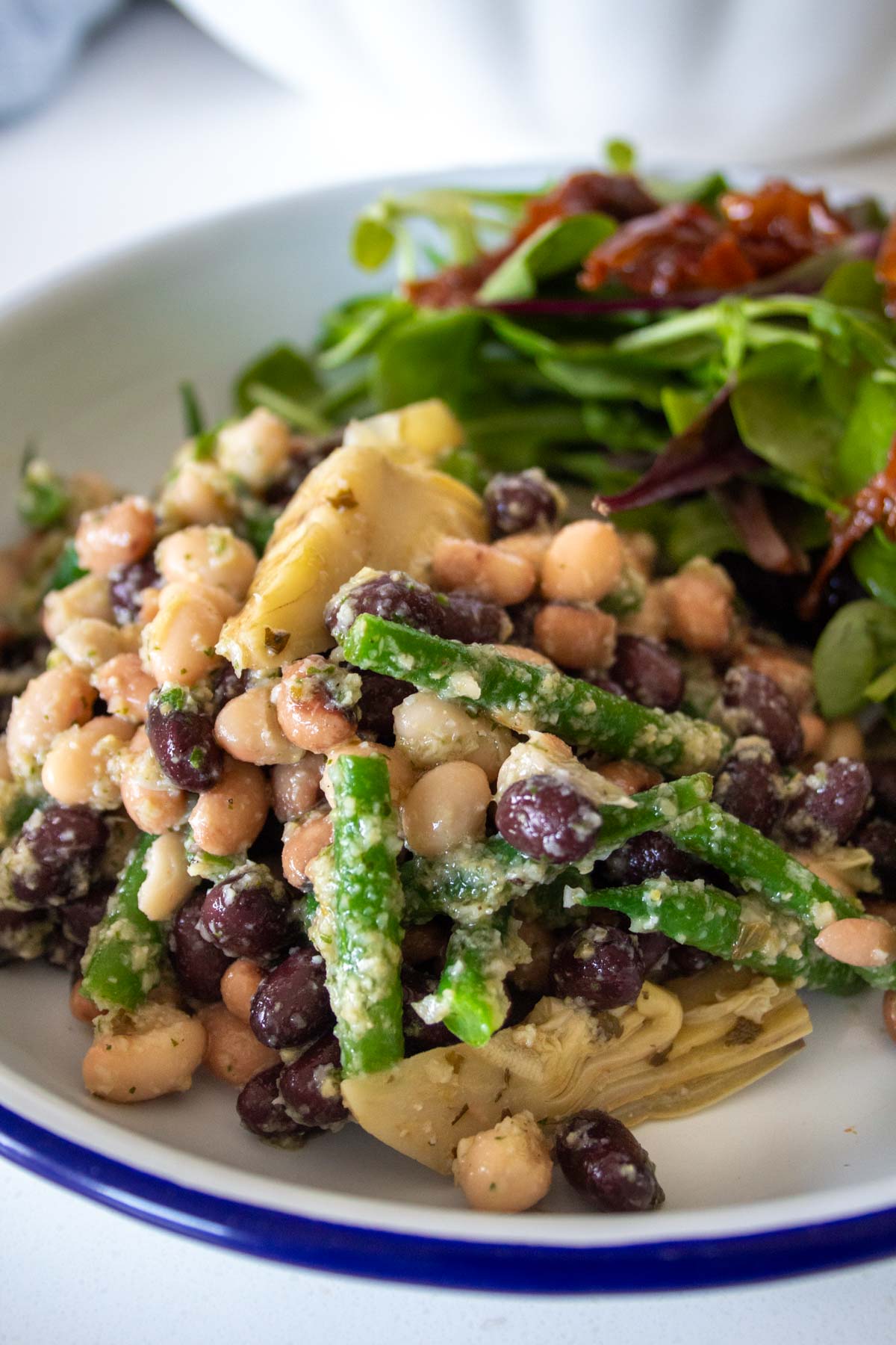 bean and artichoke salad in a dish with salad leaves