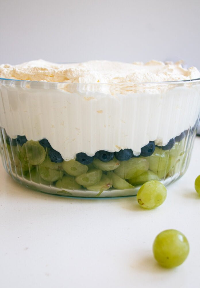 assembled grape dessert in a clear glass serving bowl without the brown sugar alternative topping