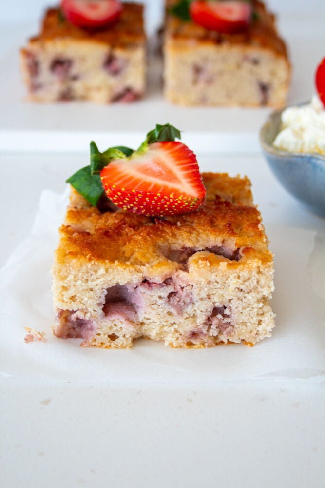 square piece of sugar free strawberry cake with a strawberry on top