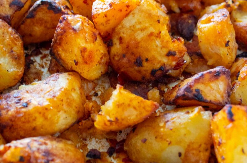closeup of harissa roasted potatoes in a roasting tray