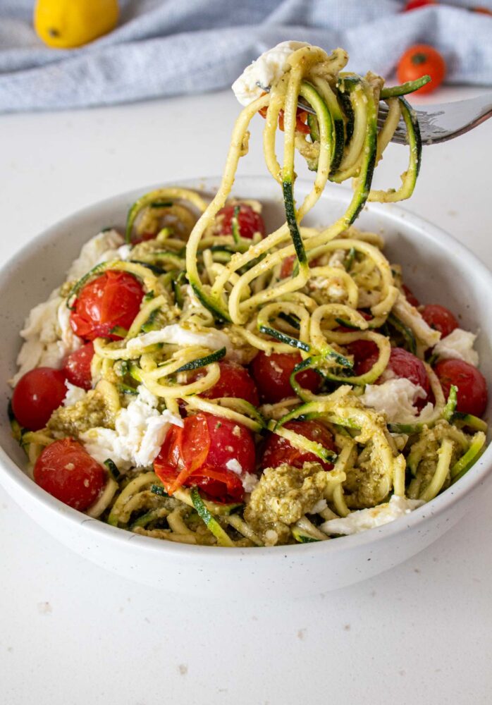 spiralised summer courgette salad in a bowl with a fork lifting some in the air