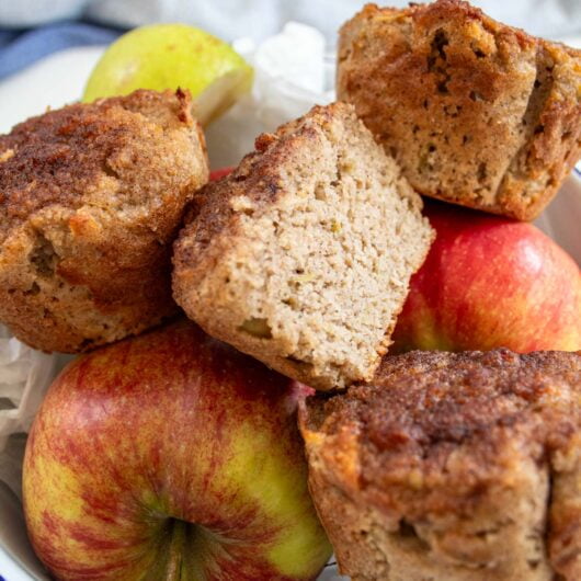 low carb apple muffins tacked on top of a bowl of apples
