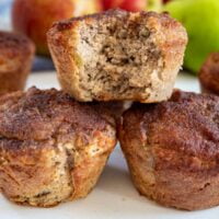 low carb apple muffins stacked with one with a bite out of it