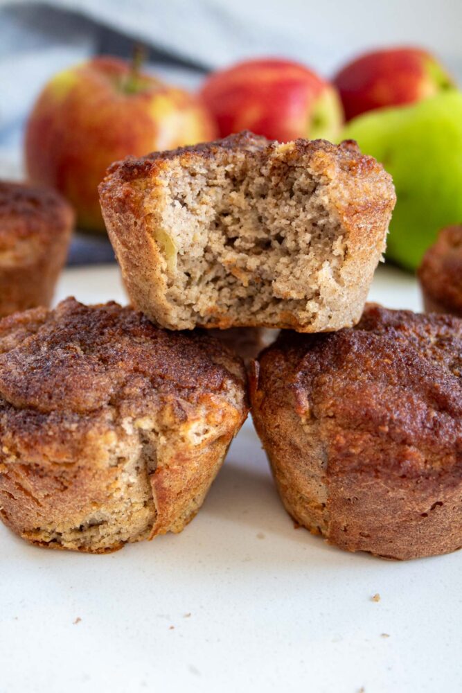 low carb apple muffins stacked with one with a bite out of it