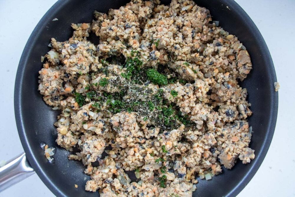 vegetarian haggis with herbs added to the frying pan