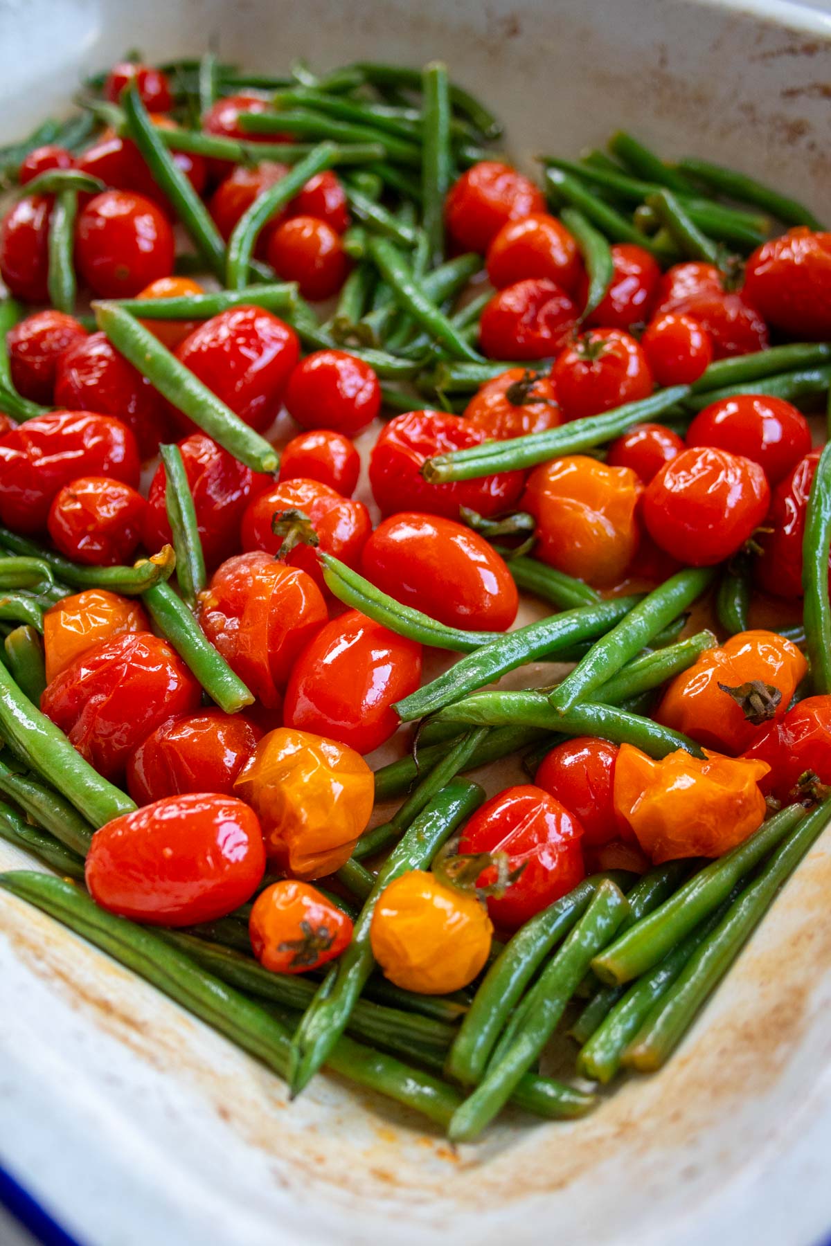 roasted green beans and tomatoes in a baking tray