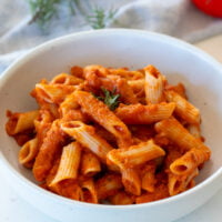 Butternut Squash Pasta Sauce mixed into penne pasta in a bowl