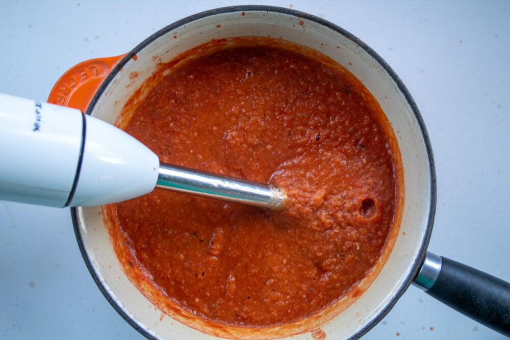 Blitzed Butternut Squash and Tomato Pasta Sauce in a saucepan with a hand blender