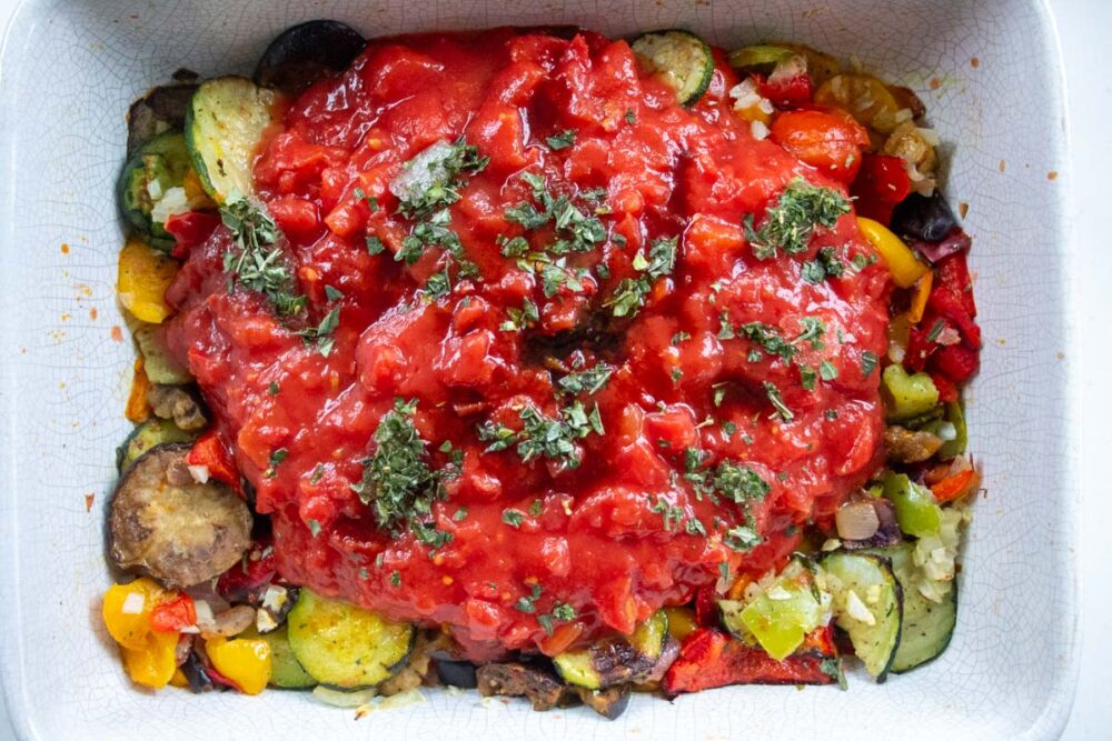 cooked frozen vegetables with tinned tomatoes and basil in a roasting dish