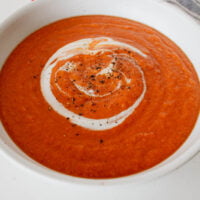 high protein tomato soup in a bowl with a yogurt swirl
