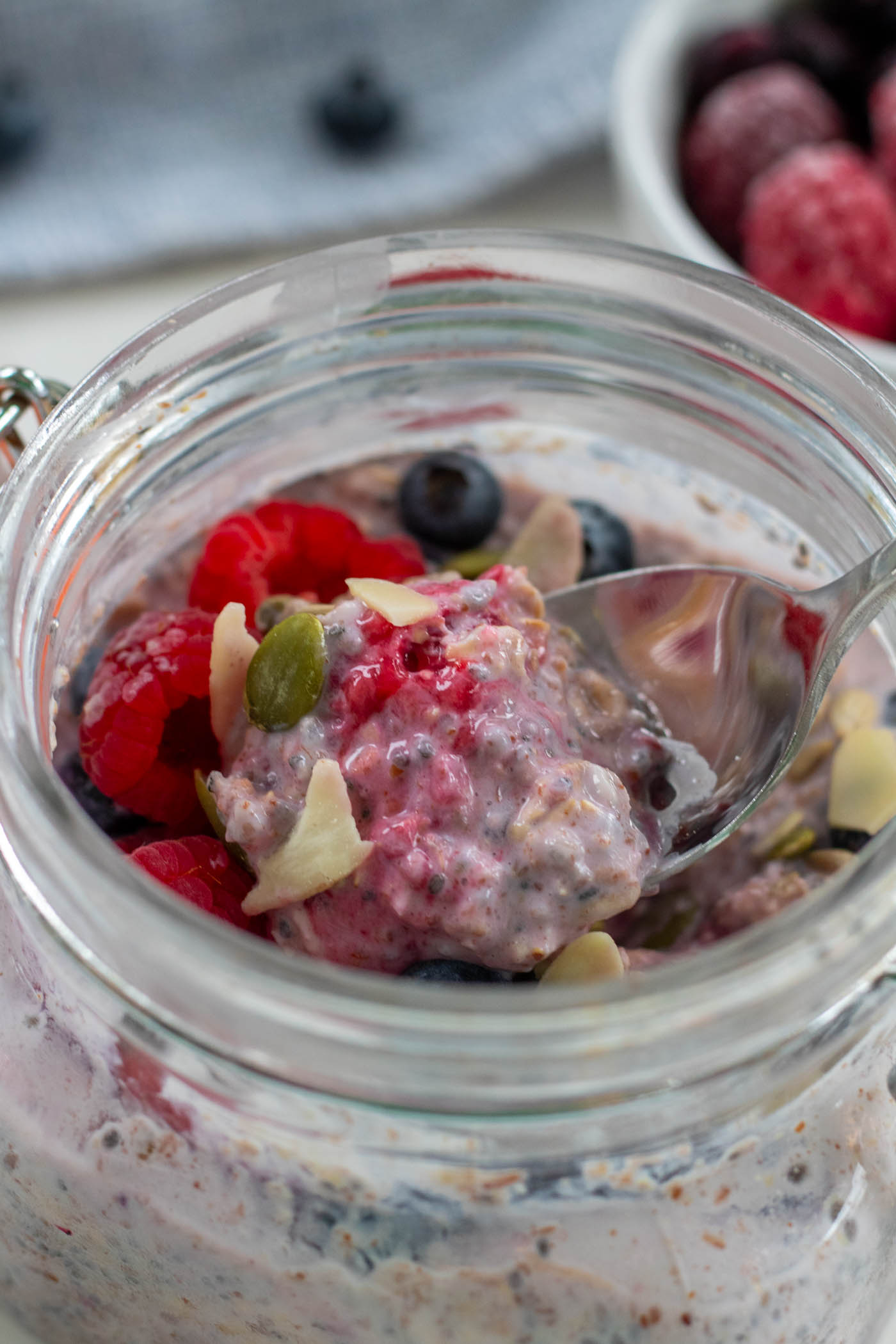 overnight oats with frozen fruit on a spoon