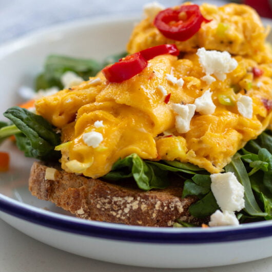 closeup of chili scramble served on top of toast and greens