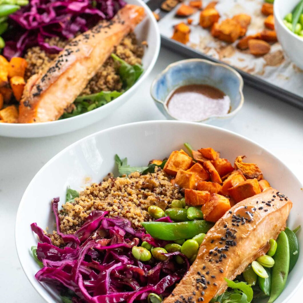 assembled nourish bowl with miso salmon red cabbage, quinoa sweet potato cubes and green vegetables