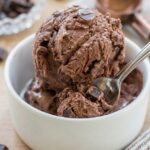 Chocolate avocado ice cream in bowl with chocolate chunks and spoon, rich homemade no churn ice cream