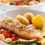 Pan-fried salmon served with courgettes, cherry tomatoes, butter beans and lemon.